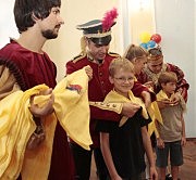Выпускники школы прошлых лет повязывают первоклашкам ярко-желтый платок с символикой ДТШ